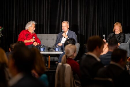 David Suzuki, Mark Carney and Valerie Pringle sit on comfortable chairs and laugh in conversation.